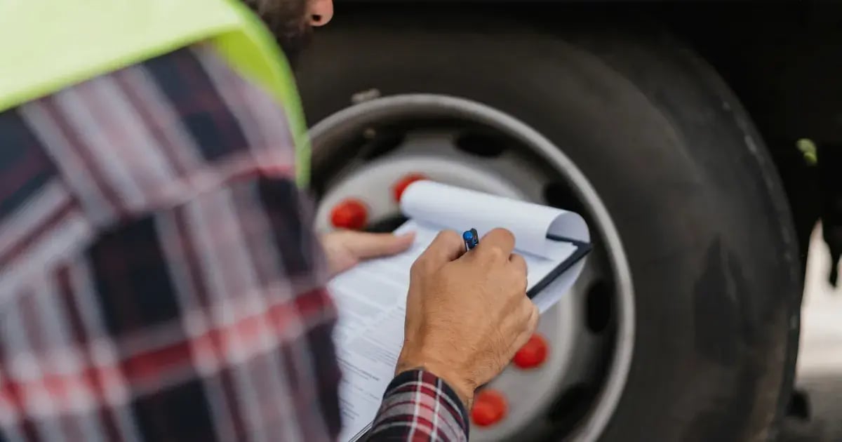 An insurance agent checking a truck for regulatory compliance