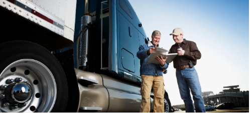 Two drivers outside truck w clipboard