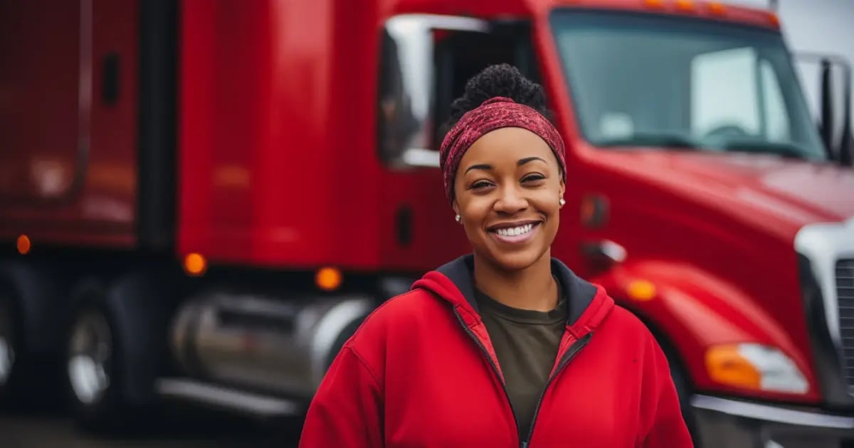 Woman truck driver smiling in front of her semi truck