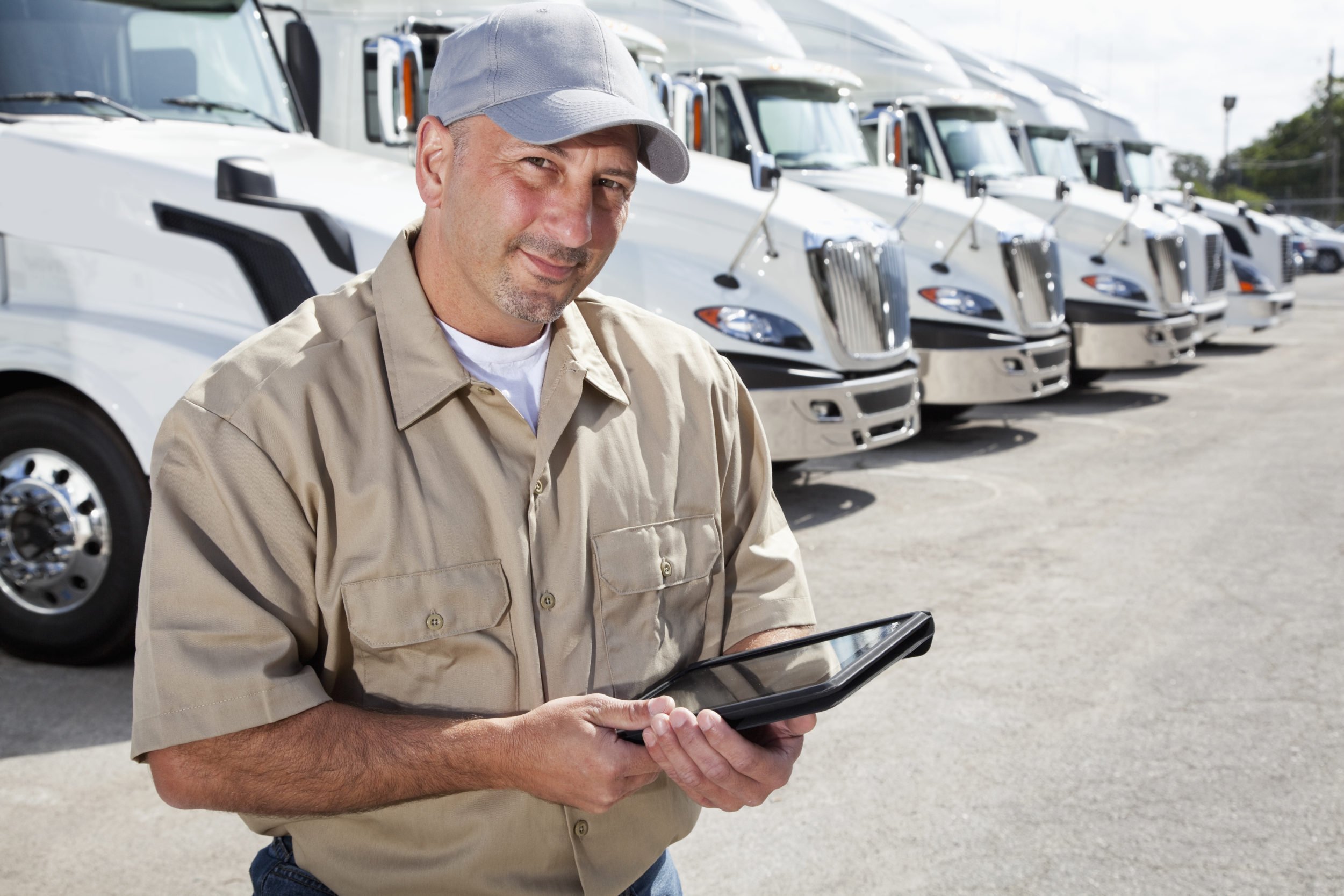 Motor carrier professional holding ELD in front of semis 